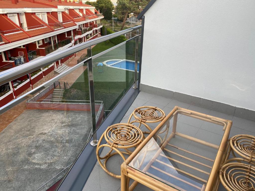 einen Balkon mit 2 Stühlen und einem Pool in der Unterkunft Apartamento Carril in Vilagarcia de Arousa