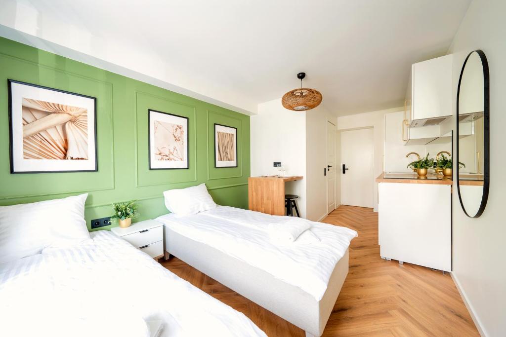 2 Betten in einem Zimmer mit grünen Wänden in der Unterkunft Tallinn Oasis Studios by RevalHome in Tallinn