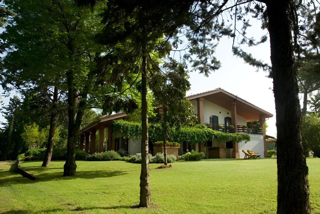 una casa en medio de un patio con árboles en Casale del fattore, en Cesena