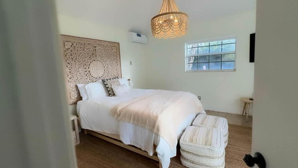 a bedroom with a white bed and a chandelier at Seahorse Beach Bungalows in Fort Pierce