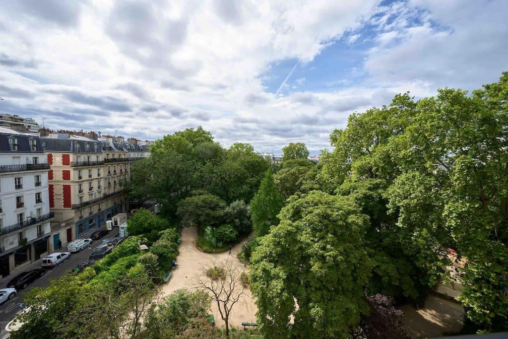 une vue aérienne sur un parc avec des arbres et des bâtiments dans l'établissement Marais - Parents Suite & Kids Room with Park View, à Paris
