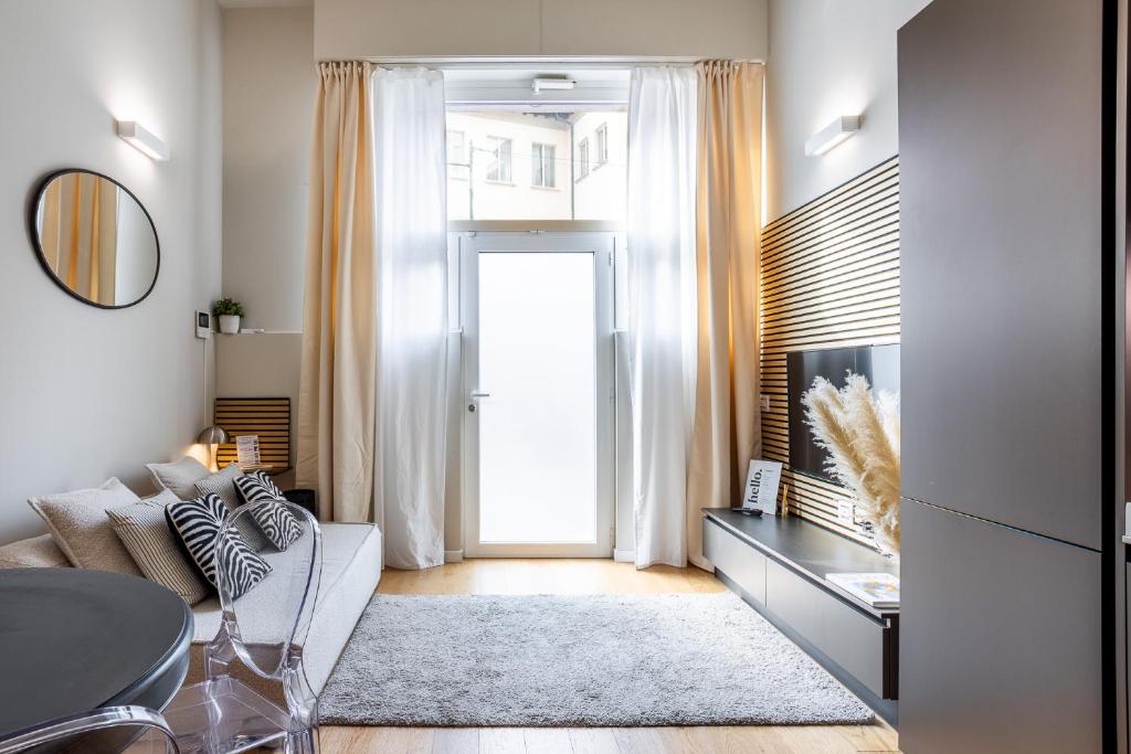 a living room with a couch and a table and a door at Duomo 9 - Luxury Modern Loft in Milan