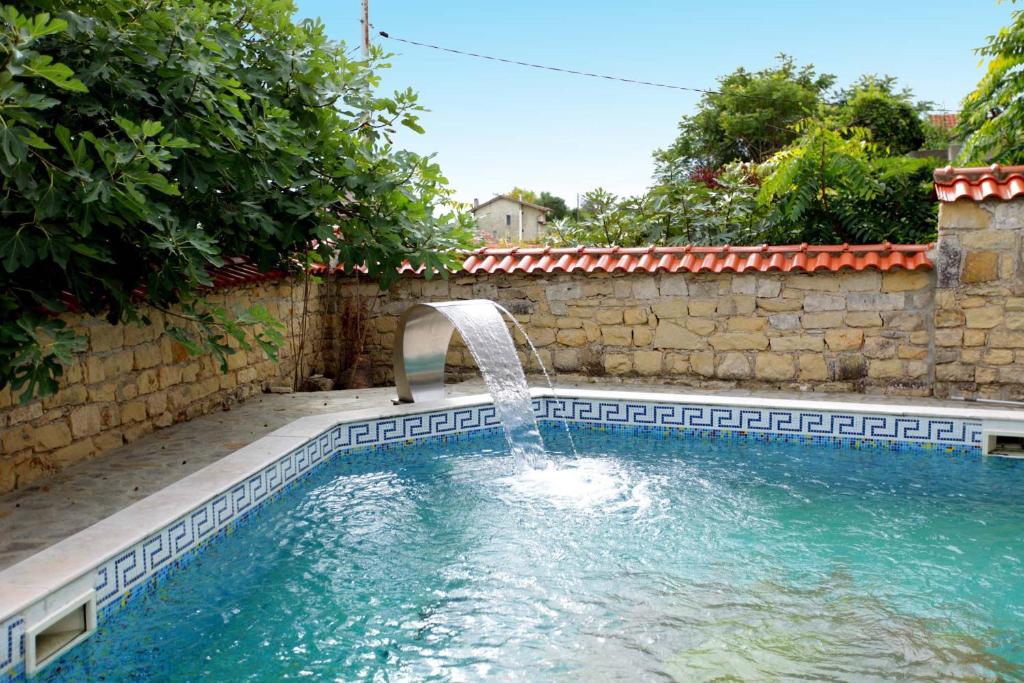 a swimming pool with a water fountain in a yard at Villa Musica in Balchik
