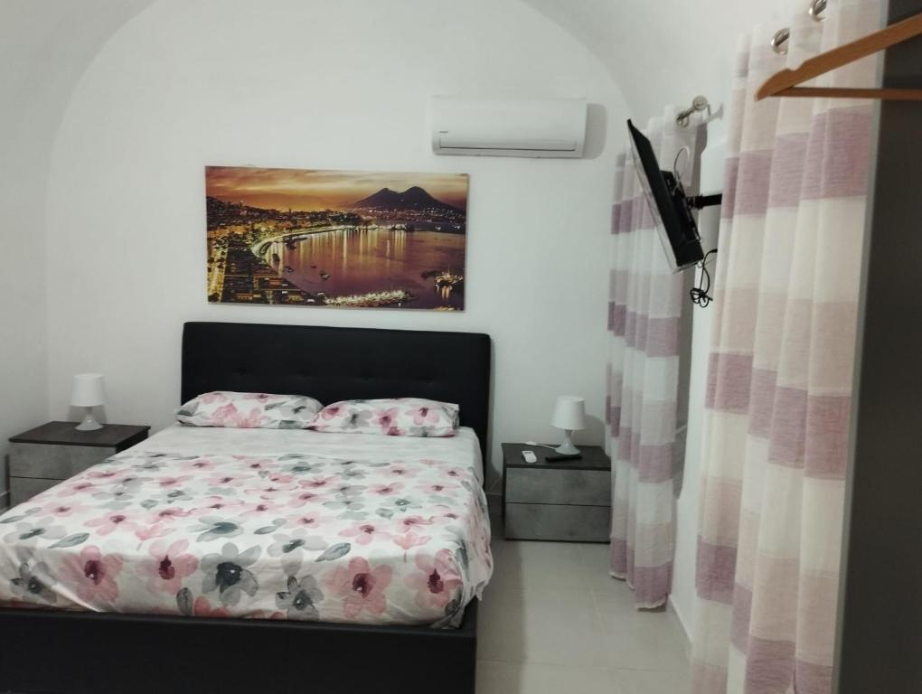 um quarto com uma cama e um quadro na parede em Il basso di Gilda em Nápoles
