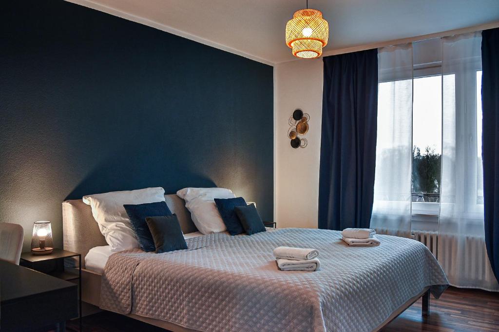 1 dormitorio con 1 cama grande y paredes azules en Deluxe! Hbf-Nähe mit Kingsize-Bett, 65 m2, en Duisburg