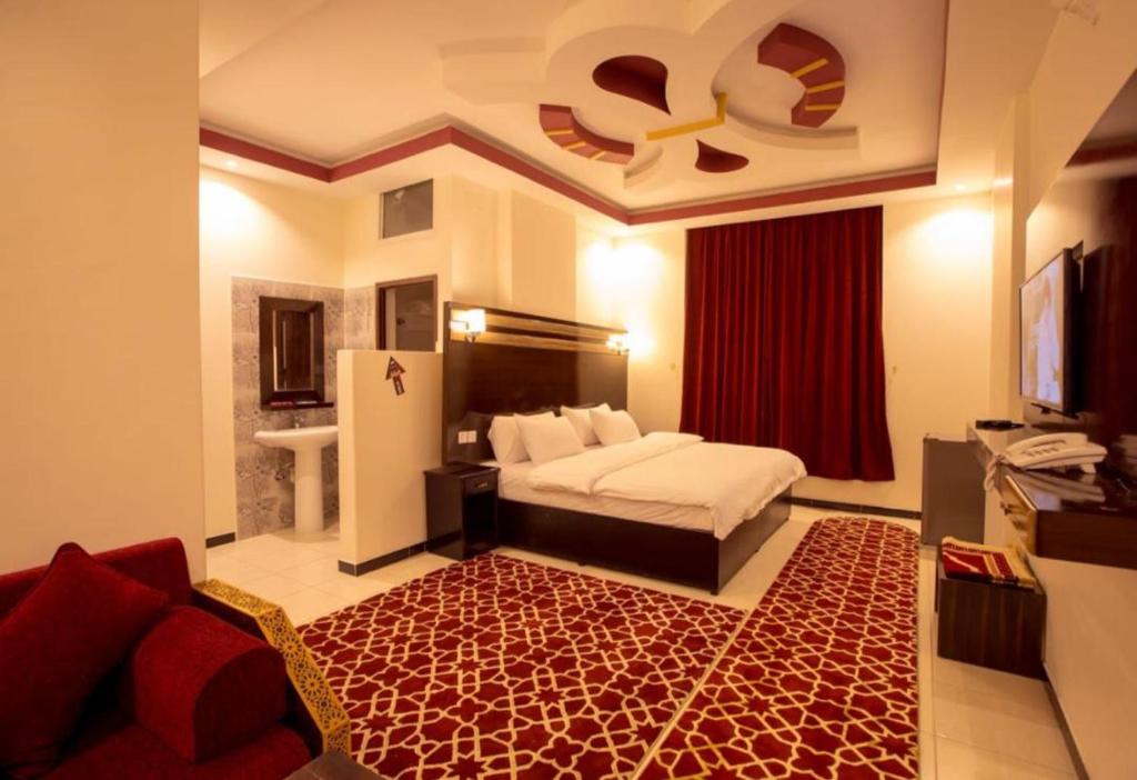 a bedroom with a bed and a red rug at فندق دروب هيلتون in Al Jardāʼ