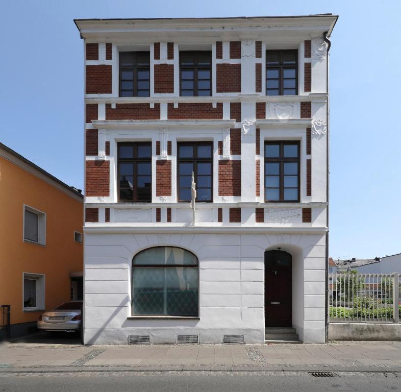 een wit gebouw met een deur ervoor bij Privatzimmer Haus Schweiz in Bonn