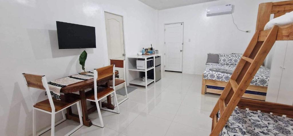 a room with a desk and a bedroom with a bed at Ina Rose Apartment and Transient 