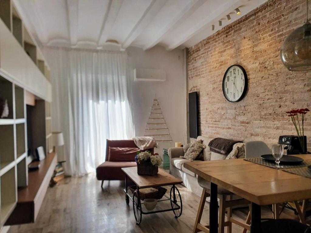 a living room with a couch and a brick wall at EF7 Beds & Family in Tarragona