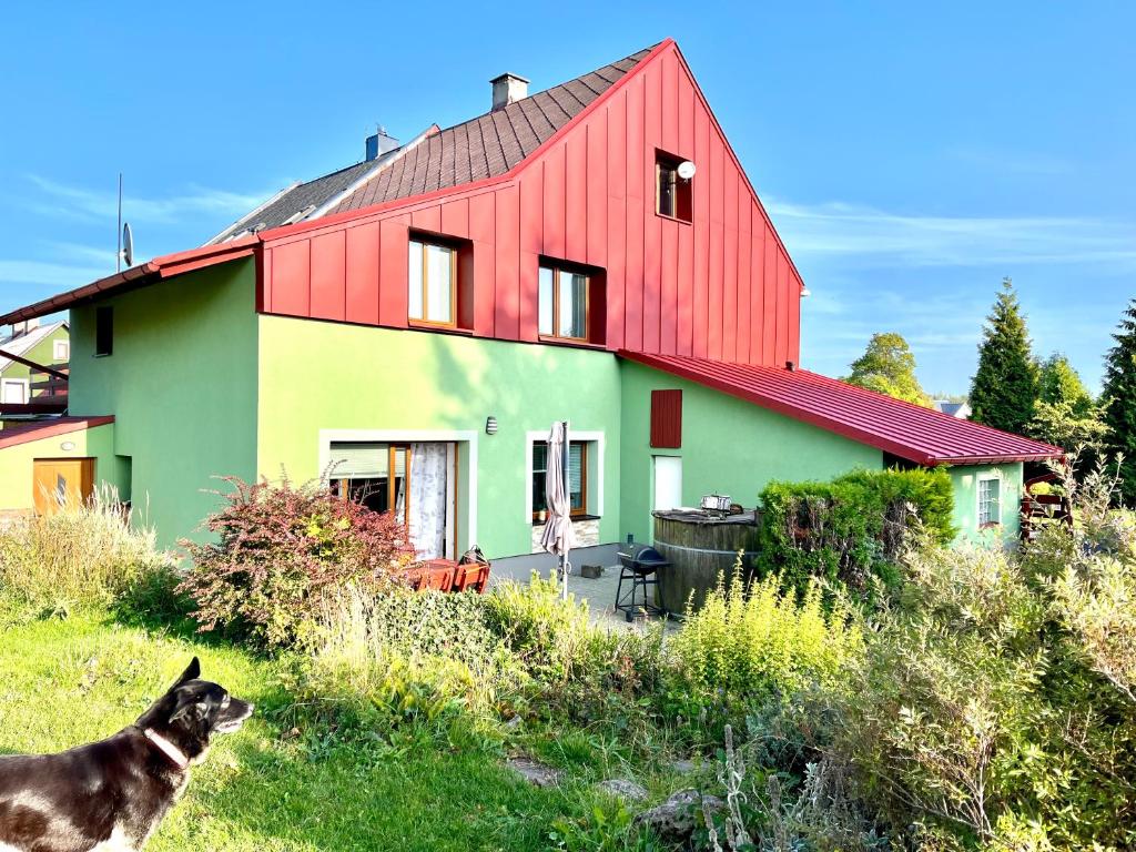 a dog standing in front of a house at Horský dům Kilian in Měděnec