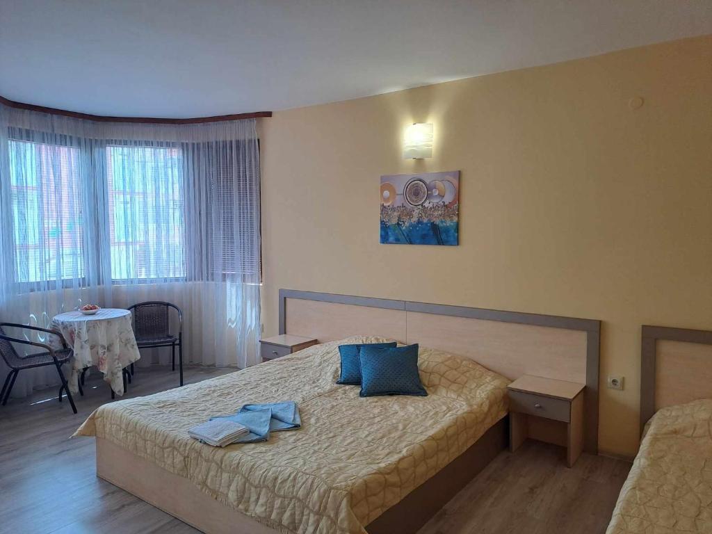 um quarto com uma cama com toalhas azuis em Къща за гости КАТИ em Kiten