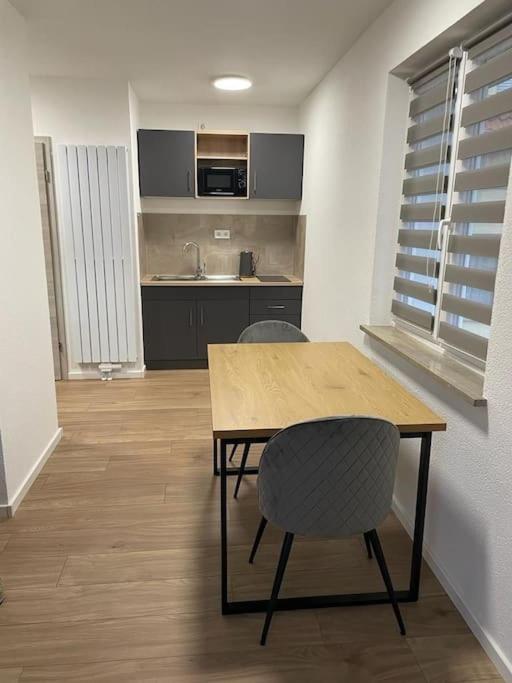 a kitchen with a wooden table and two chairs at Komplette Studiowohnung in Dinkelsbühl