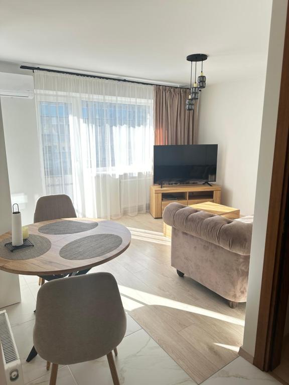 a living room with a table and a couch at Central Boulevard Apartment 2 in Šiauliai