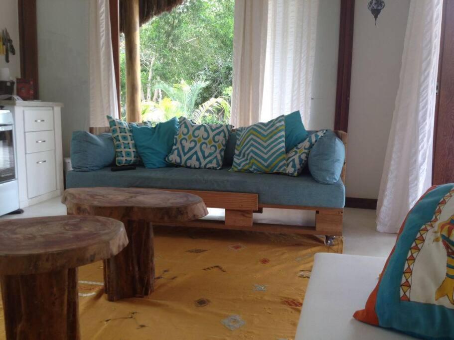 聖克魯斯－卡布拉利亞的住宿－Casa charmosa na Praia de Santo Andre/ Bahia，客厅配有蓝色的沙发和2张桌子