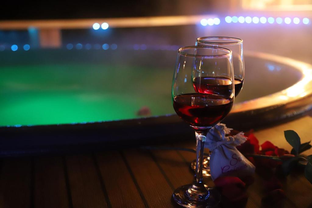 kieliszek wina siedzący na stole obok basenu w obiekcie Sowi Gościniec w mieście Sokolec