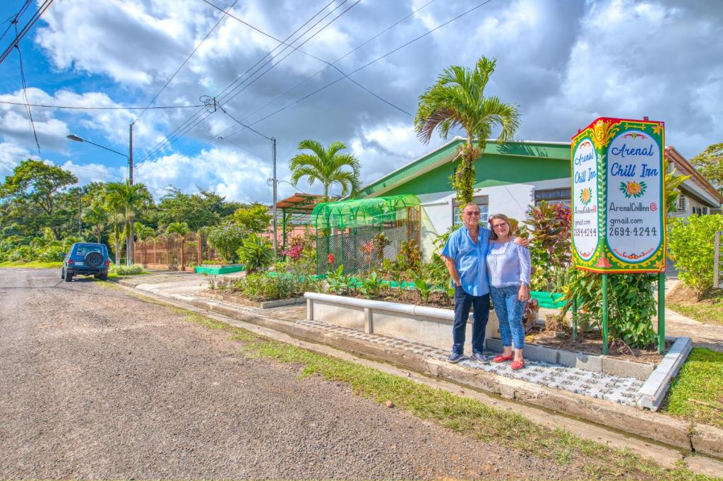 Ein Mann und eine Frau stehen neben einer Straße in der Unterkunft Arenal Chill Inn in Nuevo Arenal