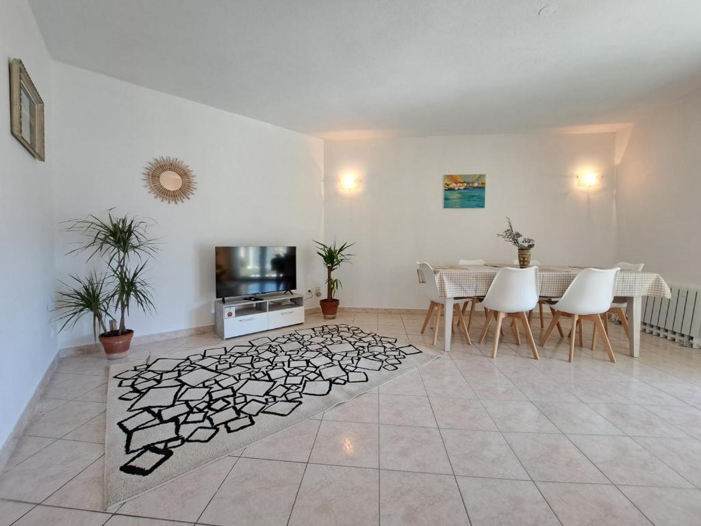 un soggiorno con tavolo e TV di Grand T2 proche centre ville, vue mer et montagne a Bastia