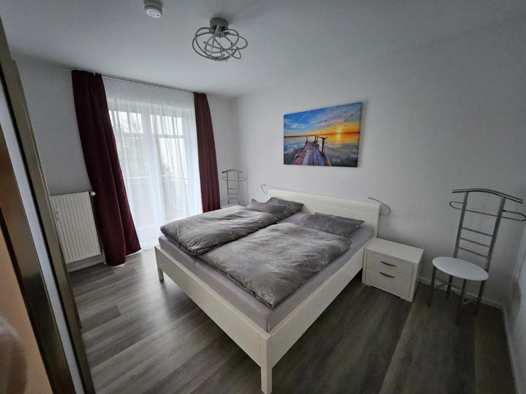 a bedroom with a bed and a table and a window at Strandallee 150a in Timmendorfer Strand