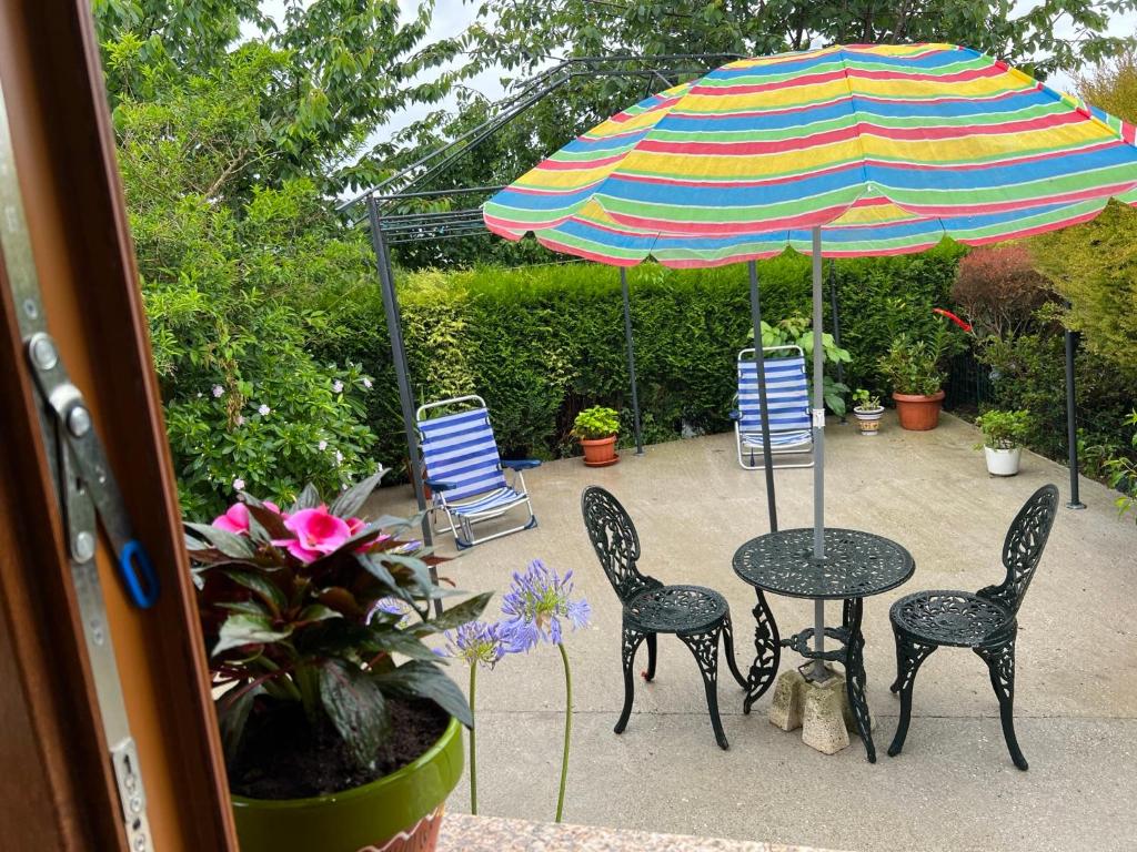 a patio with a table and chairs and an umbrella at Apartamento de Pascualin con jardin privado in A Coruña
