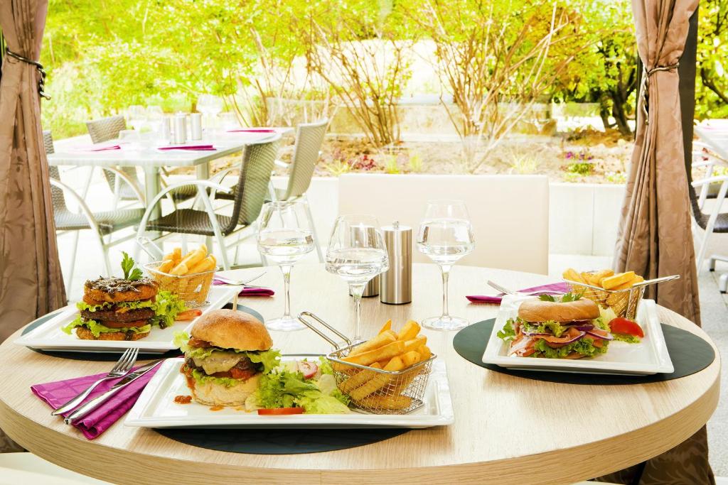 a table with two plates of sandwiches and french fries at Residhome Paris-Evry in Courcouronnes