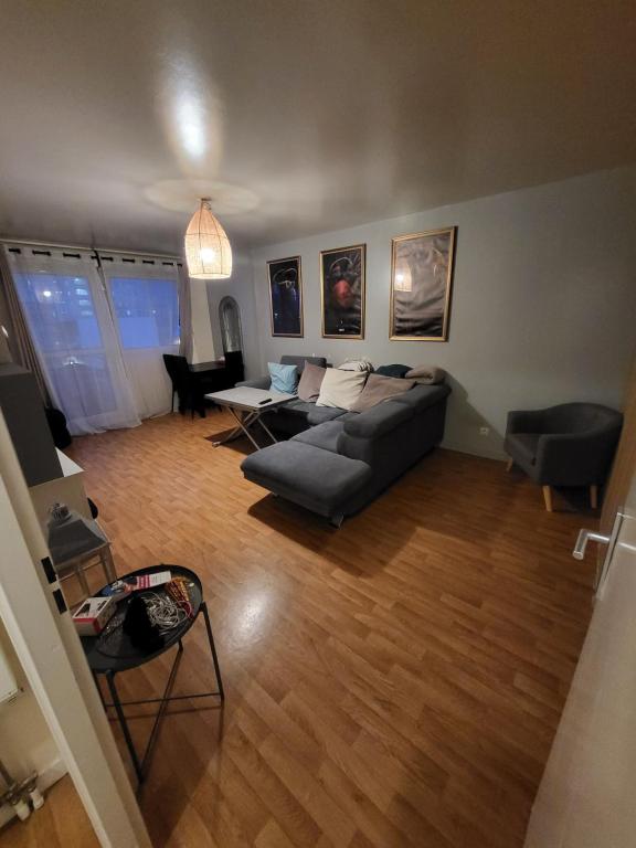 ein Wohnzimmer mit einem Sofa und einem Tisch in der Unterkunft appartement lumineux à 10mn de Paris in Romainville