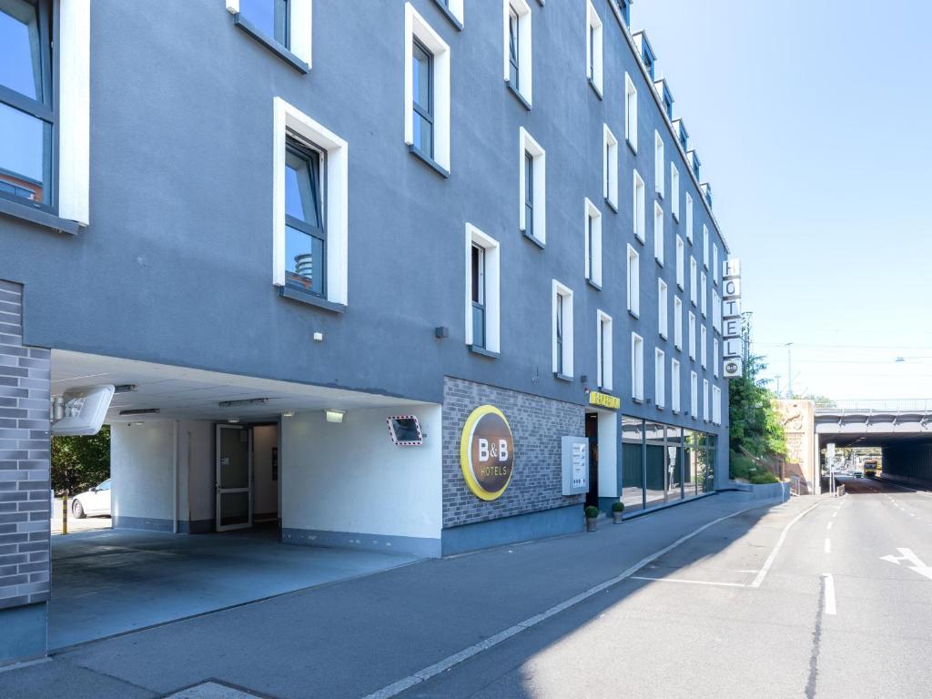 un bâtiment bleu avec un panneau sur son côté dans l'établissement B&B Hotel Stuttgart-Bad Cannstatt, à Stuttgart