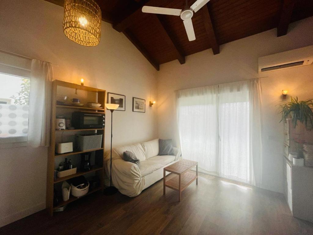 uma sala de estar com um sofá branco e uma janela em Casita independiente con jardin em Cercedilla