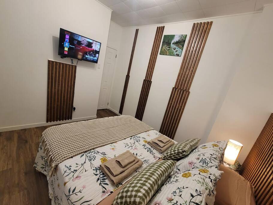 1 dormitorio con 1 cama y TV de pantalla plana en Warm cozy 1 bdrm close to Hwy, en Edmundston