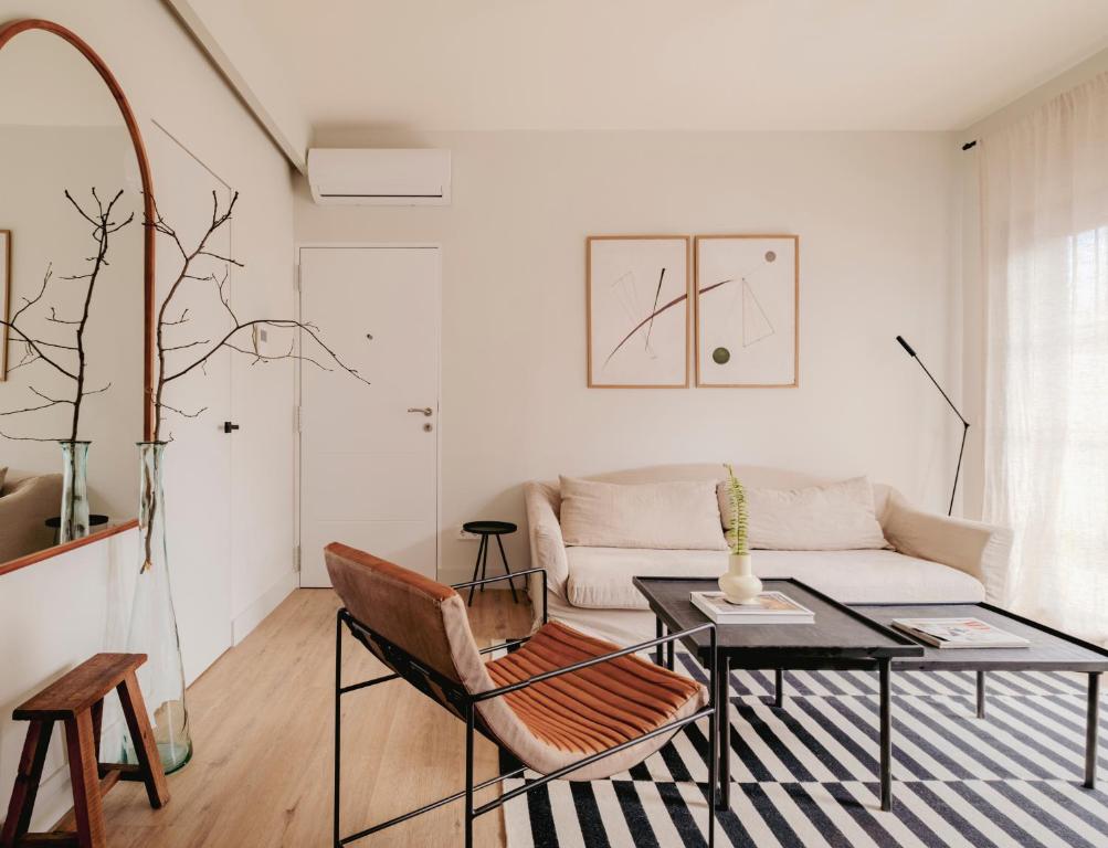 uma sala de estar com uma mesa e um sofá em Apartamento de diseño en Pozuelo em Pozuelo de Alarcón