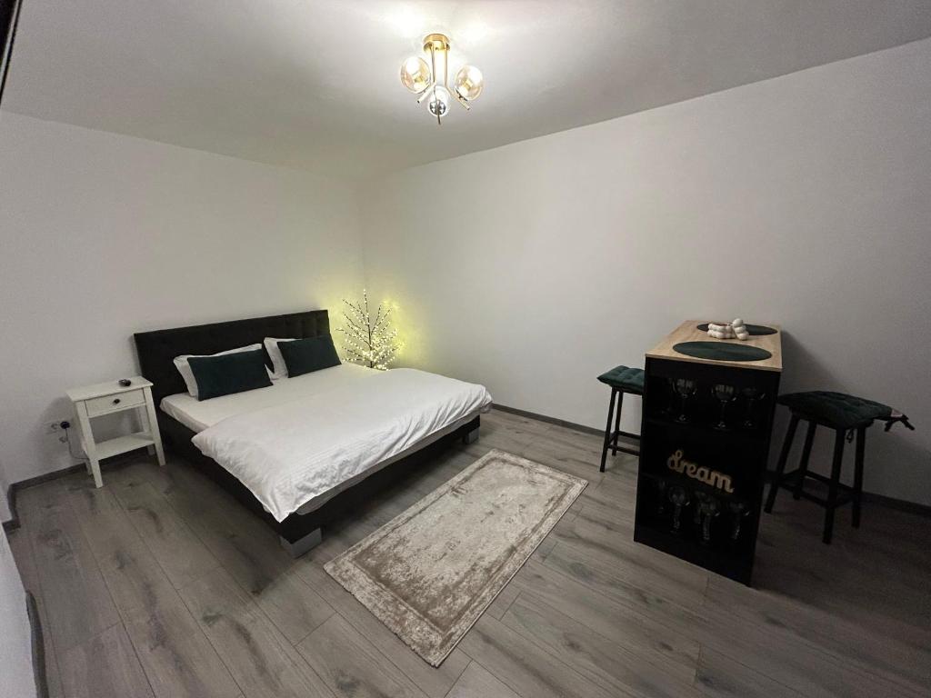 ein Schlafzimmer mit einem Bett und einem Tisch mit einem Nachttisch in der Unterkunft Cozy Home Studio in Petroşani