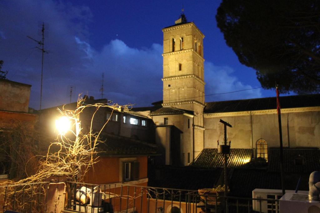 un bâtiment doté d'une tour d'horloge avec un éclairage de rue dans l'établissement Casa Greco - Attico con terrazza, Trastevere, à Rome