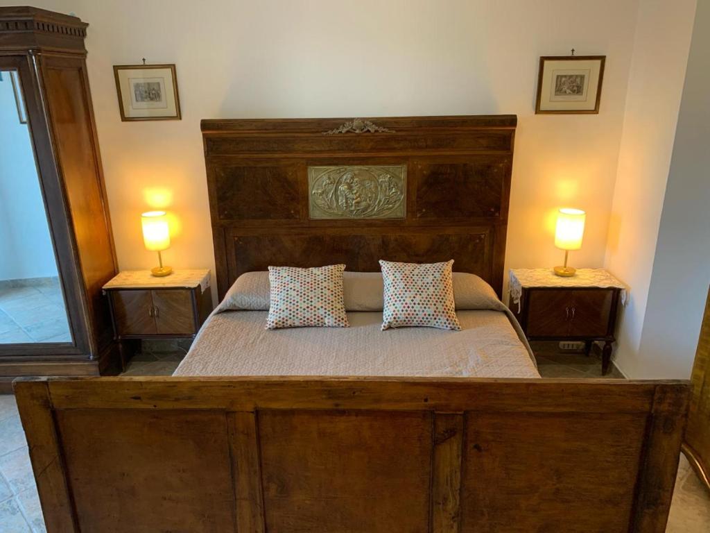a bedroom with a large wooden bed with two lamps at Il Carpino luxury historic apartment in Carpineto Romano