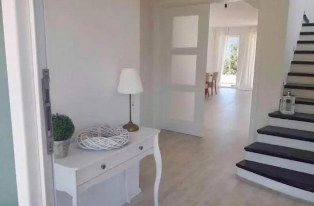 uma sala de estar branca com uma mesa e escadas em Privat Zimmer em Capljina