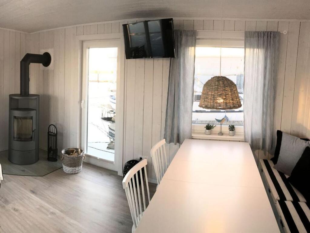 - une salle à manger avec une table et un poêle à bois dans l'établissement Houseboat NORDIC, à Großenbrode