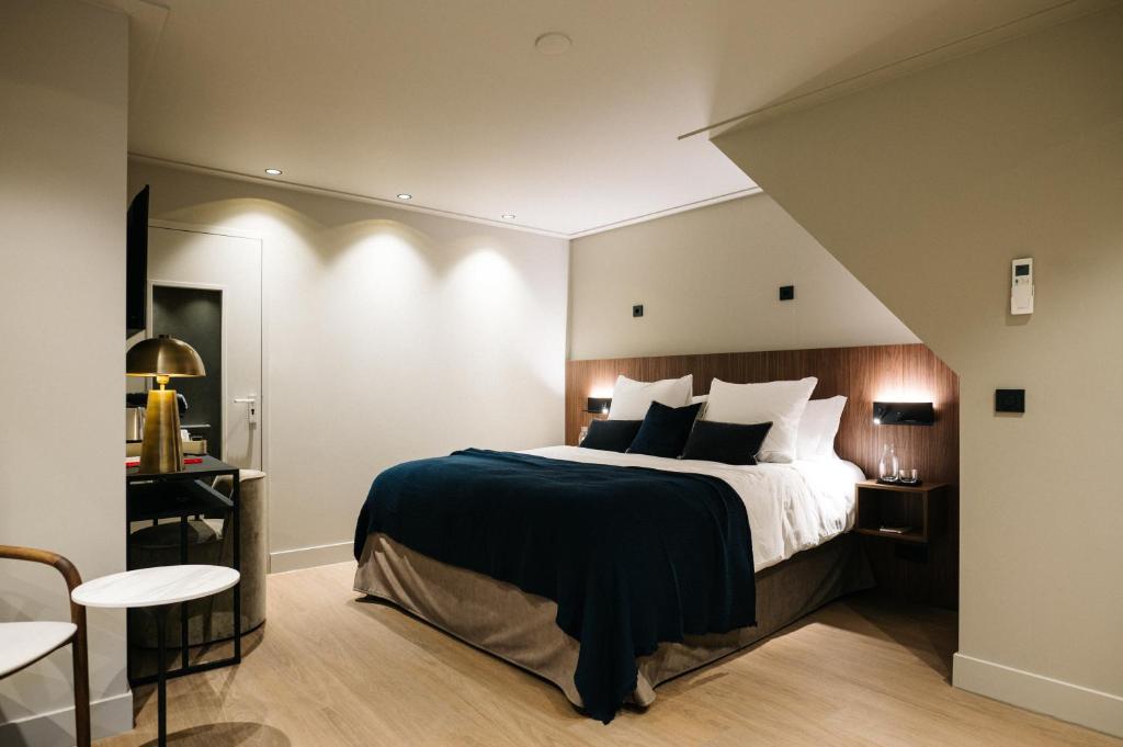um quarto com uma cama grande e almofadas pretas e brancas em Hotel Blink em Valkenburg