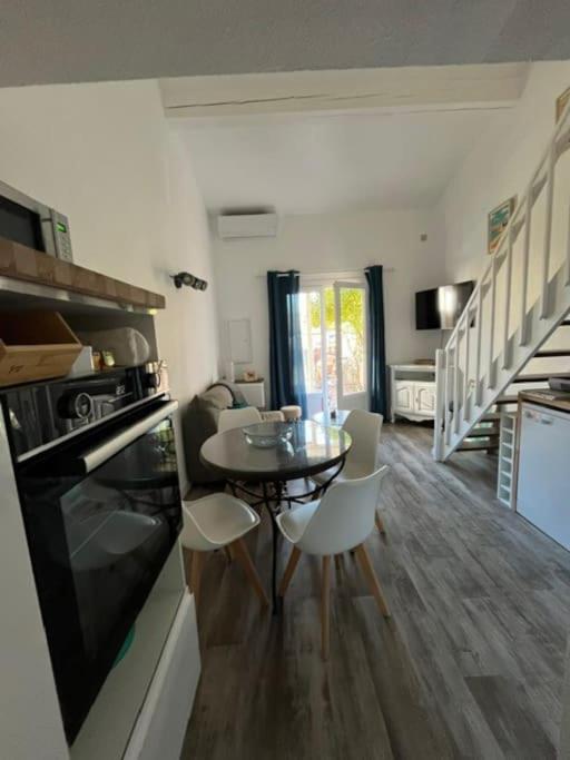 une cuisine et une salle à manger avec une table et des chaises dans l'établissement Jolie maisonnette rénovée, à Saint-Cyprien