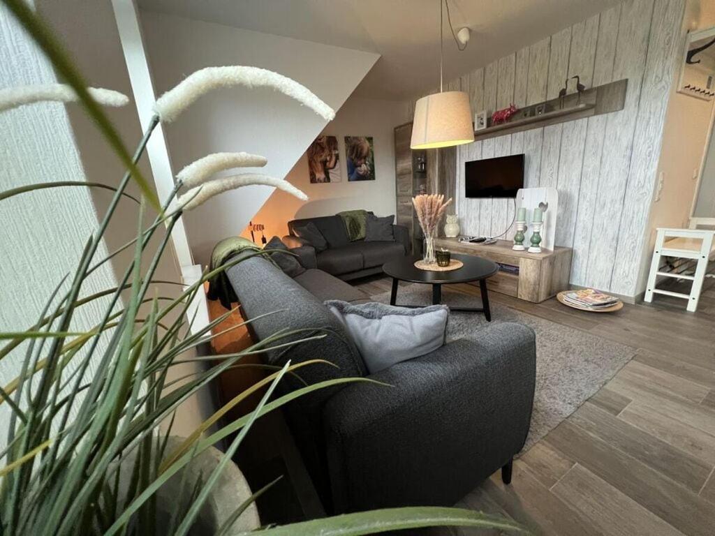 a living room with a couch and a table at Holiday apartment Ponywiese in Ihlow