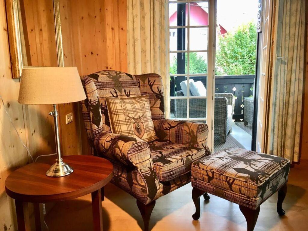 un soggiorno con sedia, tavolo e lampada di Apartment Deluxe Suite a Höchenschwand