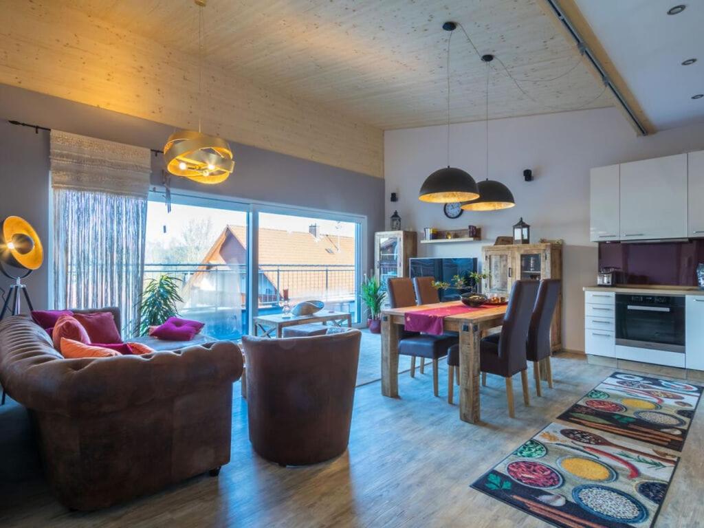 eine Küche und ein Wohnzimmer mit einem Tisch und Stühlen in der Unterkunft Penthouse Tauberblick Terrace in Tauberbischofsheim