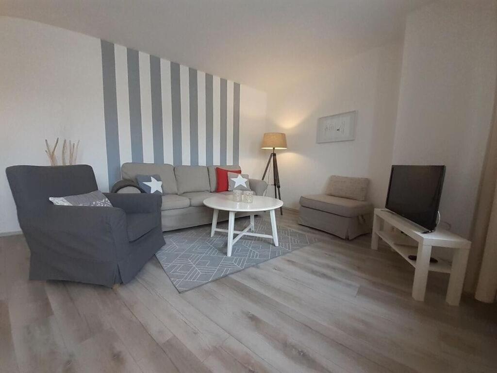 una sala de estar con un sofá y una mesa en Dornbusch Apartment 1, en Steinhude