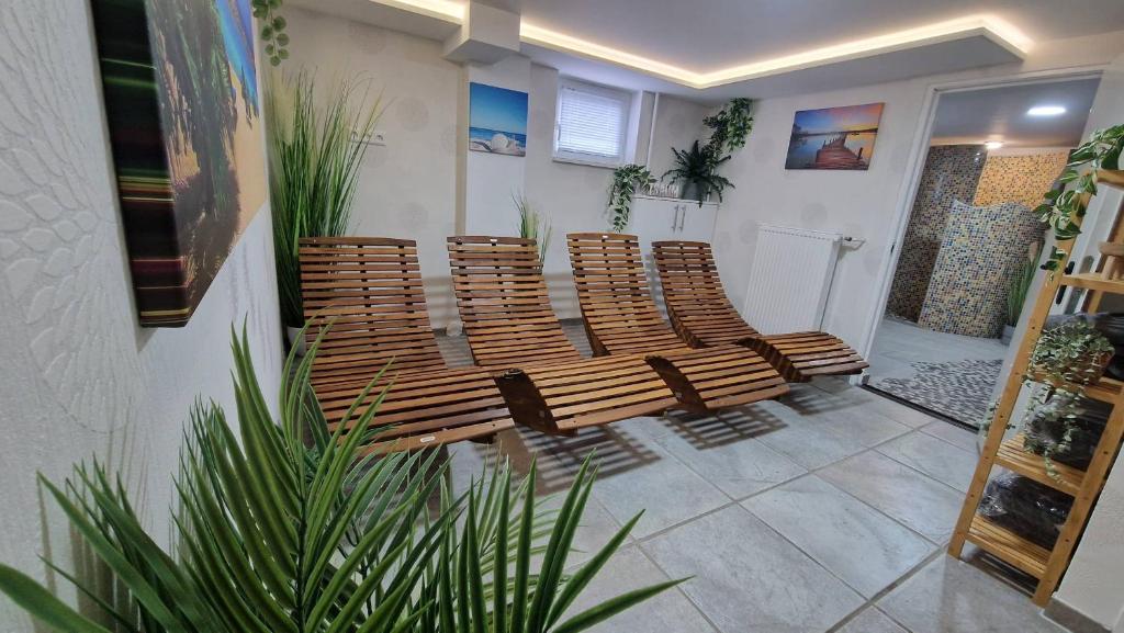 una fila de sillas de madera en una habitación con una planta en Ferienhaus Guldner mit Terrasse, Garten und Sauna, en Überherrn