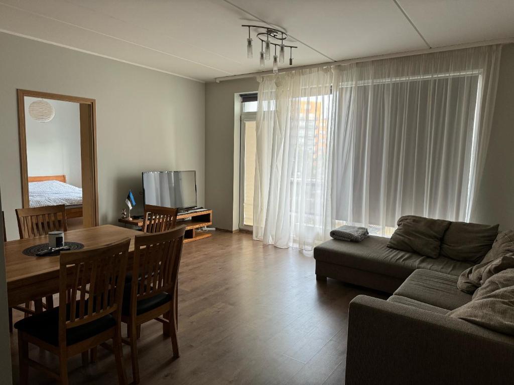 a living room with a couch and a dining room table at Beautiful apartment with sauna in Tallinn