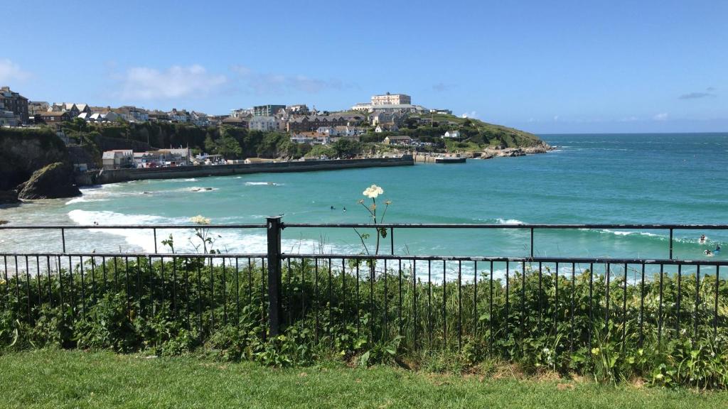 a view of a beach with a fence and the ocean at Tolcarne Guest House in Newquay