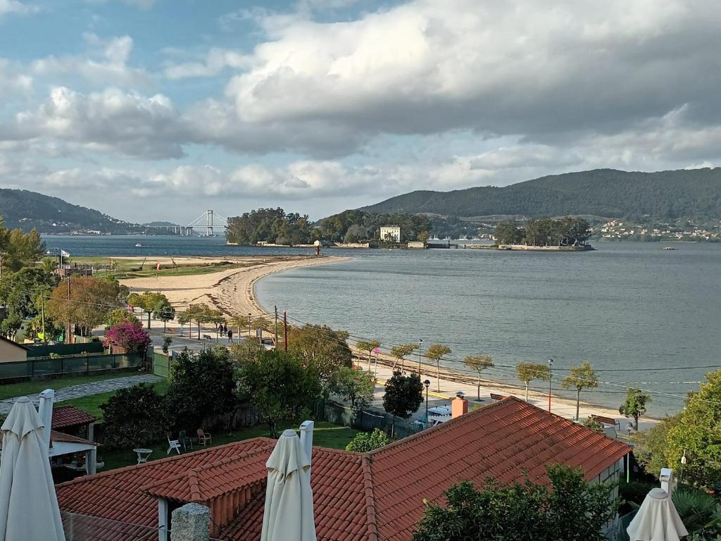 einen Blick auf den Strand und eine Wasserfläche in der Unterkunft Pensión O Regato in Redondela