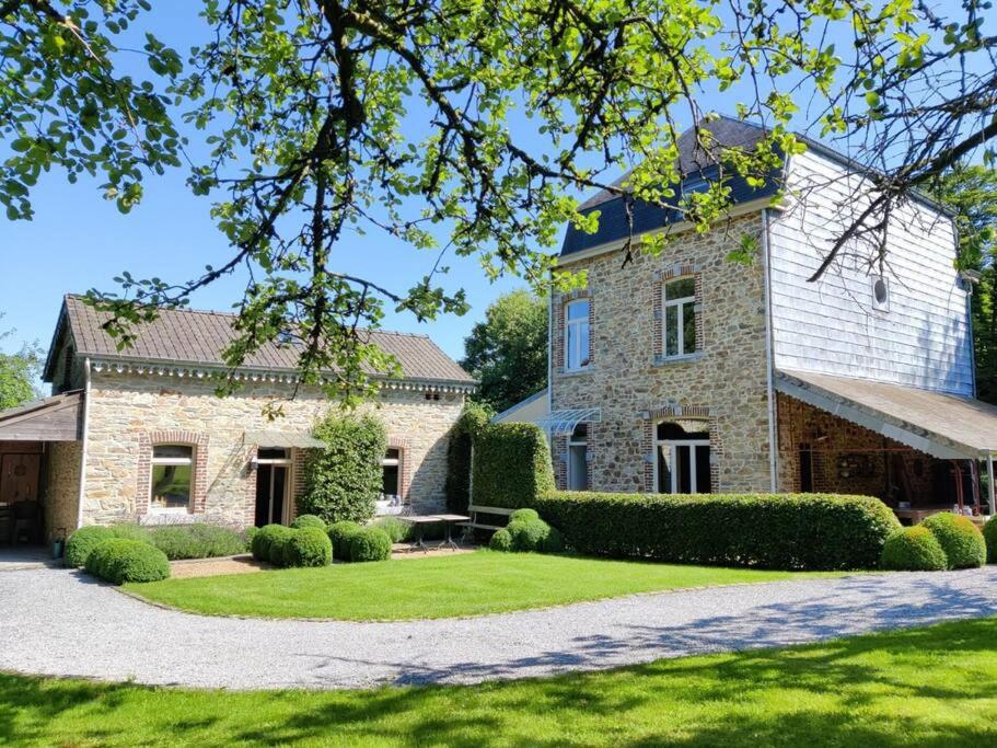 a large stone house with a grass yard at Clos des Rogations in Saint-Hubert