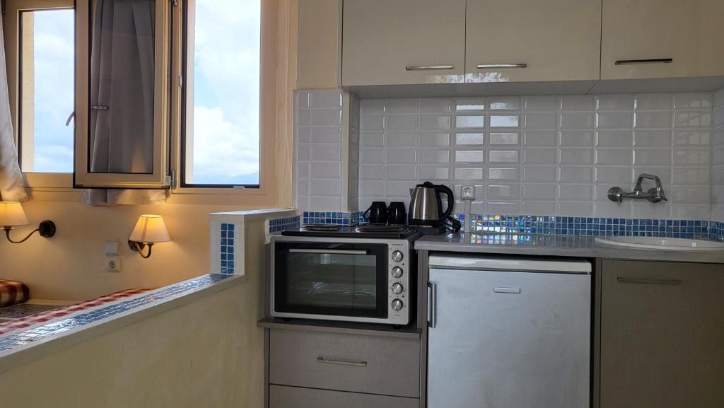 een keuken met een fornuis en een magnetron bij Sea View Apartment - Studio in Chersonissos