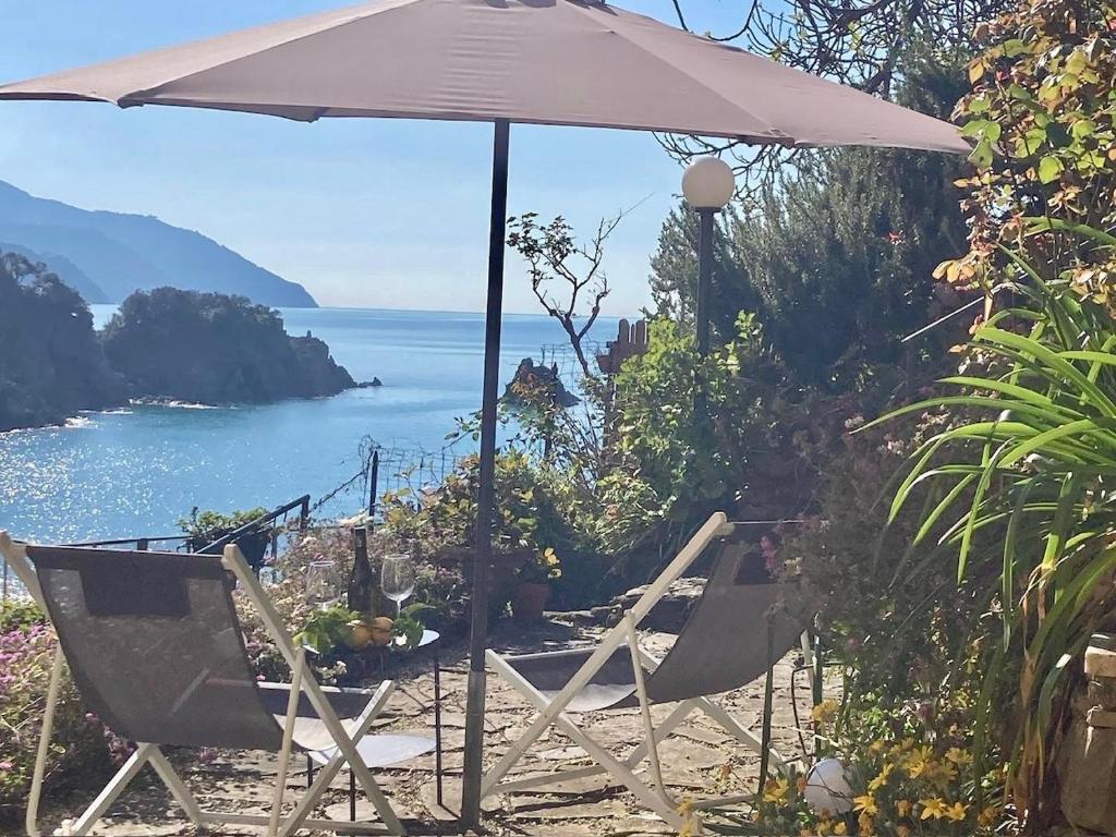 two chairs and an umbrella on a beach at Pae veciu casa vacanze in Monterosso al Mare