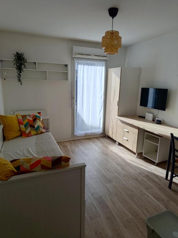 a bedroom with a bed and a tv and a window at Studio avec grande terrasse gare Sud in Nantes