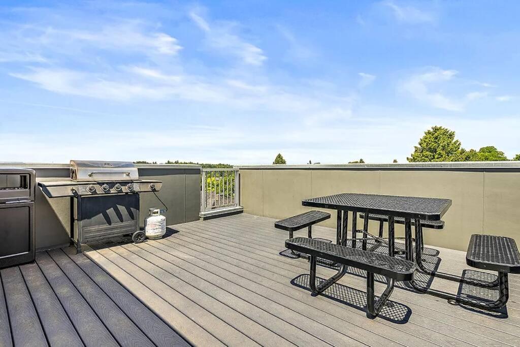 una terraza con mesa, parrilla, mesa y bancos en Pacific Trillium Studio, Wallingford 97 Walkscore, en Seattle