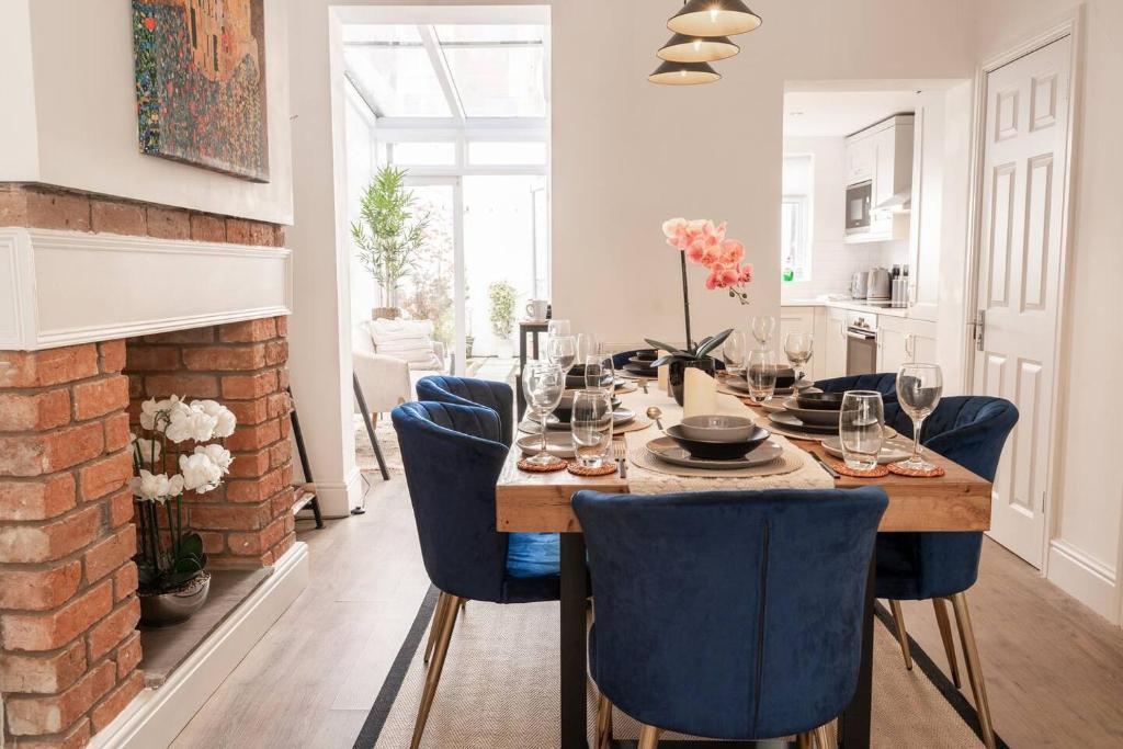 a dining room with a table and blue chairs at Stylish 3-Bed City Centre Home in Chester by 53 Degrees Property, Ideal for Groups, Private Parking! in Chester